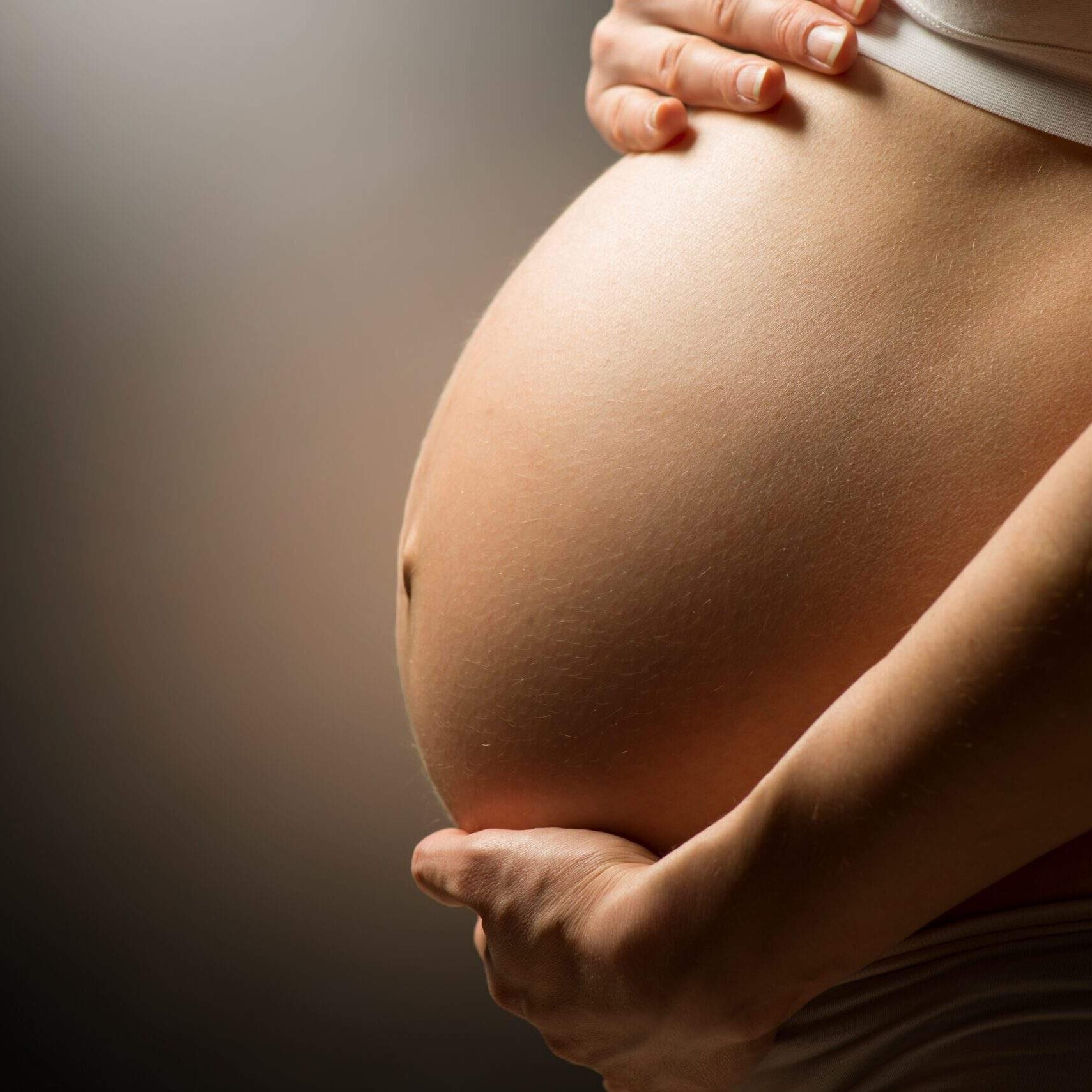 Femme enceinte soulageant le poids de son ventre
