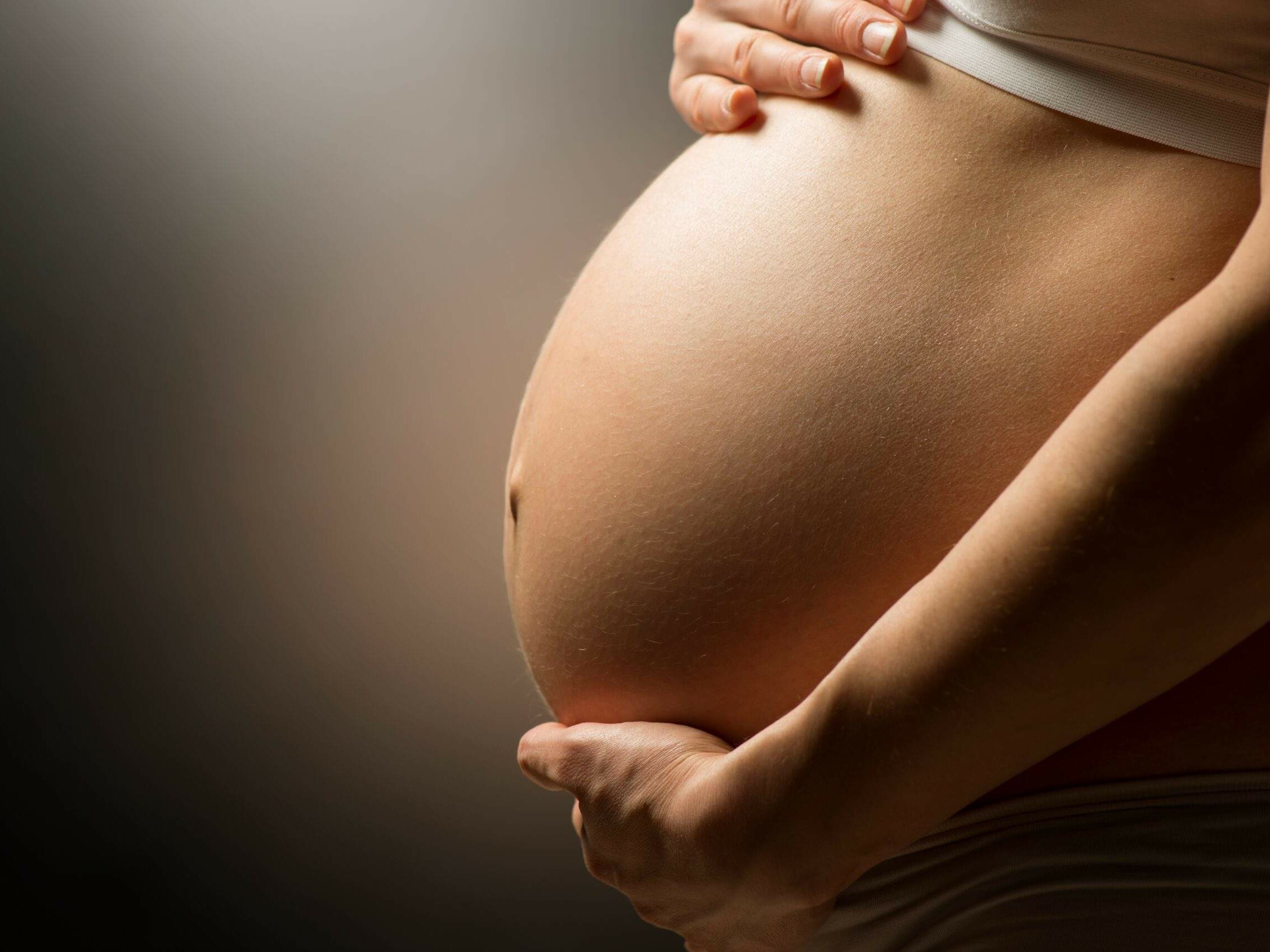 Femme enceinte soulageant le poids de son ventre